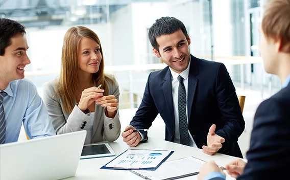 Group of people talking around a table in an office