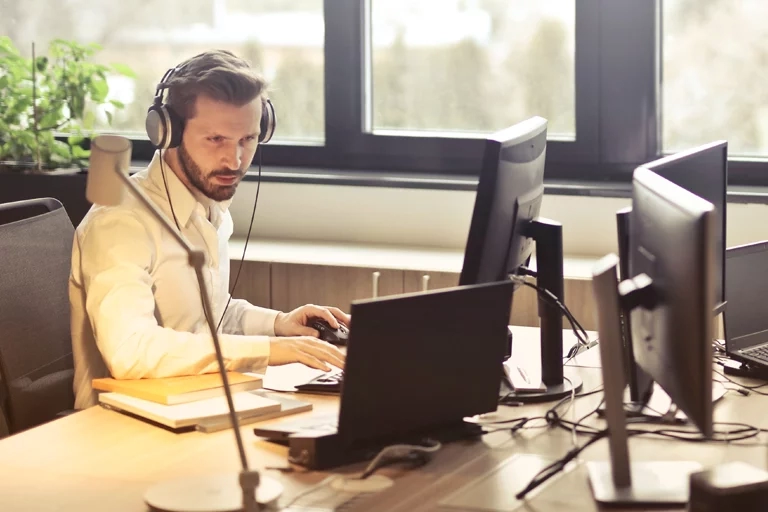 Man wearing headphones working on a computer