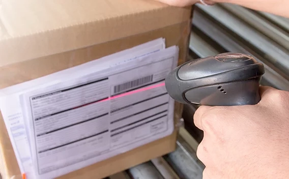 Handheld scanner scanning a barcode on a package label