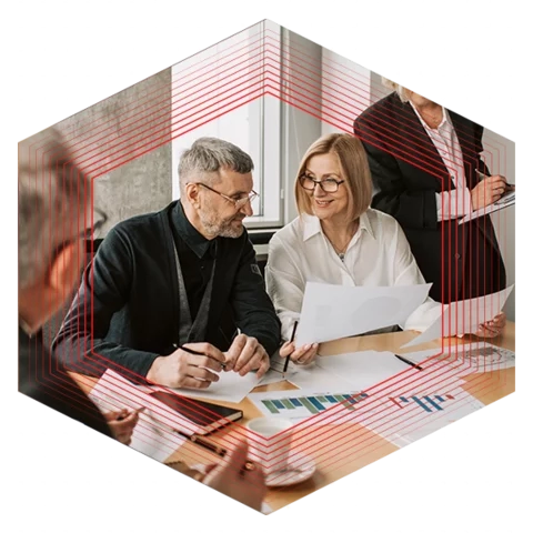 Group of people looking over papers at a conference room table in an office